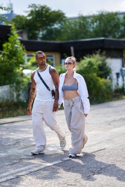 Чоловік і жінка йдуть у широких штанах та масивних снікерсах, що нагадують стиль streetwear.